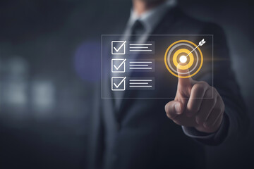 Strategic goal setting and business planning concept with a businessman pointing at a target icon and checklist. Ideal for success, productivity, project execution and leadership content. 