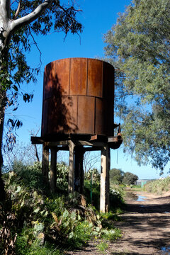 Old rusty elevated water tank standing on concrete pillars