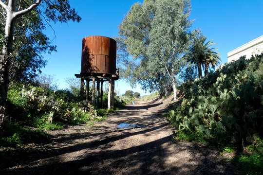 Old rusty elevated water tank standing on concrete pillars