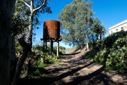 Old rusty elevated water tank standing on concrete pillars