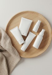 White skincare products displayed on a wooden tray with fabric  
