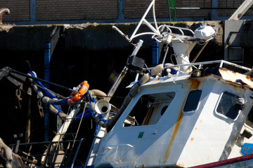 Sunken fishing boat partially submerged in harbor, maritime accident scene