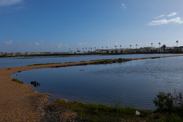 Salt marshes reflecting the blue sky near the city of faro in portugal