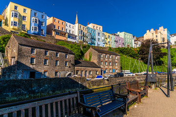 Fototapeta premium A view towards coloured buildings above the harbour in the early morning in Tenby, South Wales in summertime
