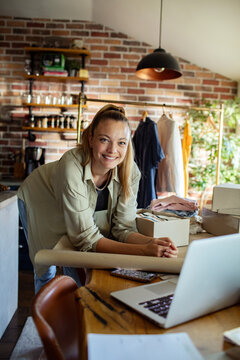 Young woman working on online boutique small business from home office