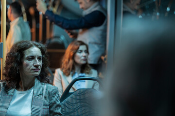 Obraz premium Businesswoman commuting by bus looking away during night trip
