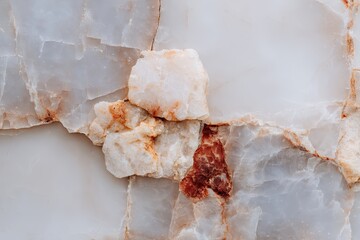 Close-up of a light beige and off-white stone surface with irregular, fractured pieces