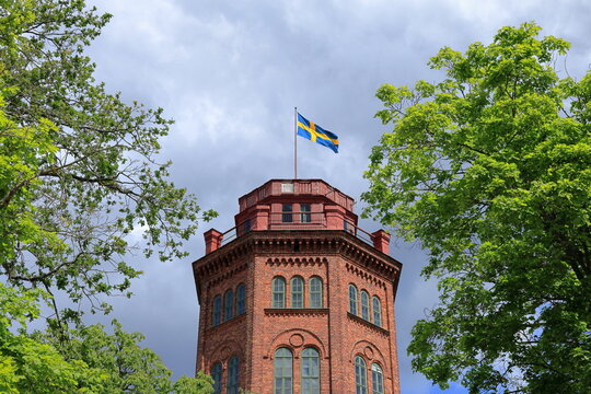 One old building called Bredablick tower. Skansen, Djurg&aring;rden, Sweden. Swedish flag at the top.