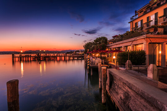 View of golden sunset and restaurant overlooking Lake Garda, Sirmione, Lake Garda, Lombardy, Italian Lakes, Italy