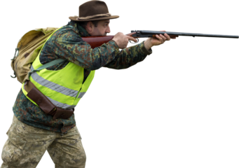 Hunting period, autumn season open. A hunter with a gun in his hands in hunting clothes in the autumn forest in search of a trophy. A man stands with weapons and hunting dogs tracking down the game.