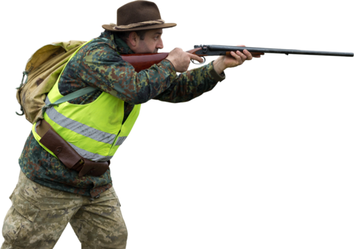 Hunting period, autumn season open. A hunter with a gun in his hands in hunting clothes in the autumn forest in search of a trophy. A man stands with weapons and hunting dogs tracking down the game.