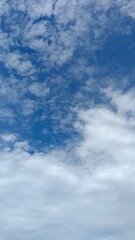 Obraz premium Layered clouds with soft cumulus below a textured altocumulus blue sky
