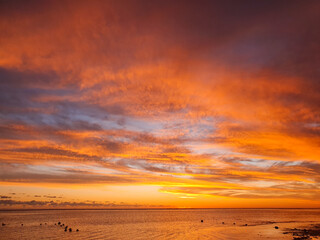 Farbenprächtiger Sonnenuntergang über dem Meer von Mauritius mit Wolken und sanften Wellen