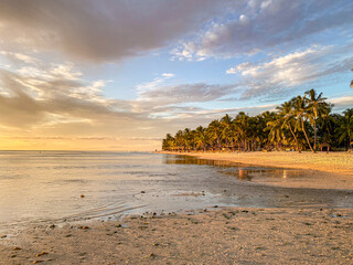 Orangener Sonnenuntergang am Strand von Mauritius mit Palmen