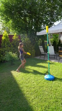 Girl playing tetherball outdoors in summer, enjoying active fun and recreation