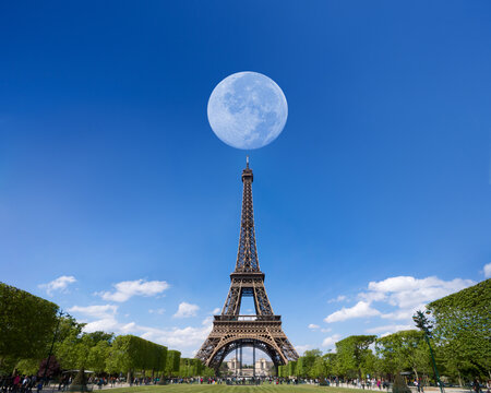 Eiffel Tower is a wrought iron lattice tower on the Champ de Mars in Paris, France. Famous tourist attractions, traveler's destinations. Astronomical phenomenon, Full moon during day on top Eiffel.