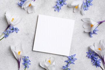 Blank square greeting card mock up with spring white and blue flowers on a textured gray background, creating an elegant and serene atmosphere for design purposes