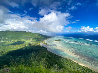 Weite Sicht mit grüner Landschaft und dem türkisblauen Meer auf Mauritius bei sehr gutem Wetter