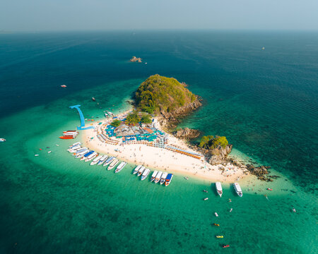Aerial view of boats lining the shore of Koh Khai Nok, the turquoise water contrasting with the white sand and lush greenery, Phru Nai, Phang Nga, Thailand.