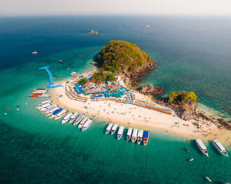 Aerial view of Koh Khai Nok island with boats docked on the shore, contrasting with the turquoise waters, Phru Nai, Phang Nga, Thailand.