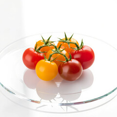 Illustration of colorful cherry tomatoes on a glass plate isolated on white background