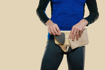 Closeup of half dressed man wearing medical orthopedic bandage. Man showing insert in groin hernia...