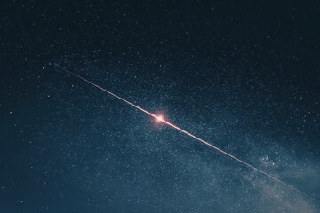 Meteor streaks across the night sky illuminating the stars as it burns up upon entering Earth's atmosphere