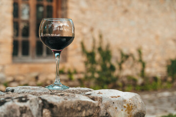 Glass of Red Wine in Front of Stone Wine Cellar in France or Italy