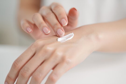 Elegant woman applying luxurious hand cream for soft skin and youthful beauty treatment