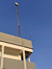 building with small dish antenna tower on the rooftop