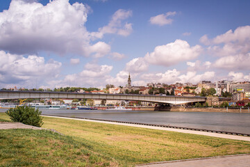 Naklejka premium The bridge over the Danube River in Belgrade, Serbia. Cruise boats are moored along the riverbanks.