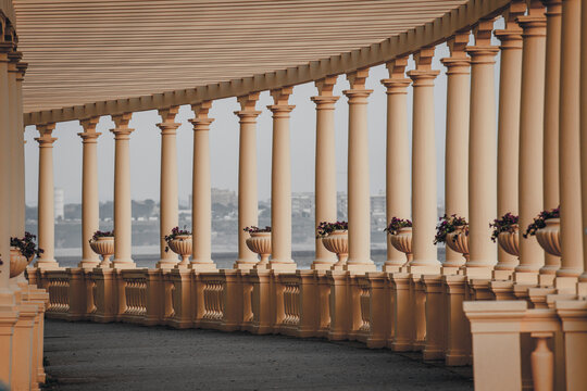 Porto, Portugal - 17 June 2022: View of the Pal&Atilde;&iexcl;cio de Cristal gardens' curved colonnade, its soft, warm tones contrasting with the distant cityscape and the cool, calm river beyond.