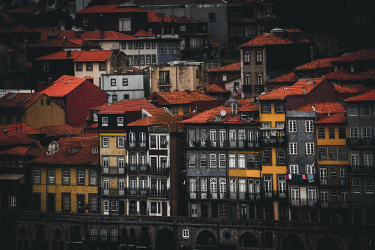 Porto, Portugal - 17 June 2022: View of the Ribeira district's buildings cascading down towards the Douro River, a symphony of ochre, sienna, and umber creating a warm, historic panorama.