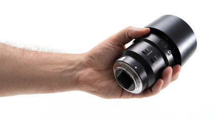 New camera lens held in a hand for examination
