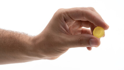 Holding a small yellow circular object in hand