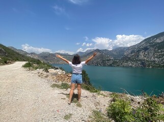 Naklejka premium Scenic view of Green Canyon in Turkey with turquoise lake and mountain range in background. Summer travel destination with clear sky and natural landscape.