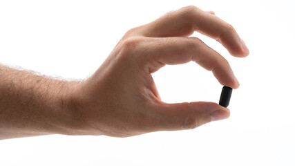 Fototapeta premium Hand holding a black capsule