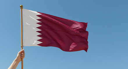 Waving National Flag of Qatar Against Clear Blue Sky