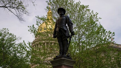 A statue of Stonewall Jackson stands proudly against the backdrop of the West Virginia State Capitol. This historic landmark features lush greenery and elegant architecture.