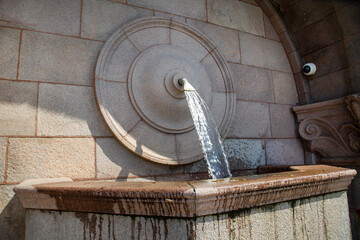 A pipe with flowing drinking water with a granite container in the city on a clear sunny day, Moscow.  Sights of Russia. Architecture of World tourism.