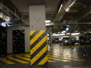 Blurred view of an Underground parking seen through a rain-covered window