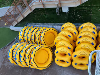 Stacked yellow inflatable rings and rafts in water park