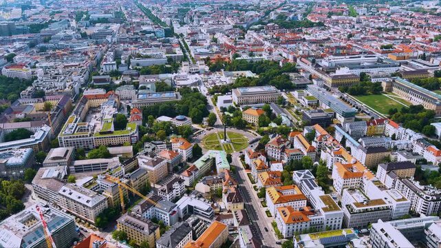4K drone aerial view of Munich&rsquo;s Museum Quarter: Karolinenplatz obelisk, tree-lined ring roads, K&ouml;nigsplatz temples and Pinakothek galleries form a vibrant mosaic of Bavarian culture and city life.