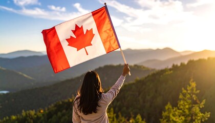 Person holds flag aloft on mountaintop at sunset