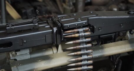 Close-up detail of a historic German MG 42 general-purpose machine gun. An ammunition belt with cartridges is fed into the receiver of the World War II era automatic weapon.
