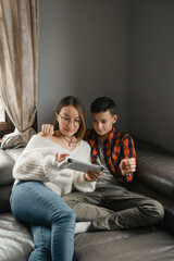 Mother and son occupied with their tablets. Leisure time of modern family, Teenager boy Online gaming with no Digital detox. Middle school student
