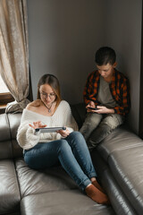 Mother and son occupied with their tablets. Leisure time of modern family, Teenager Online gaming with no Digital detox. High school student