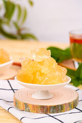 Handmade ancient yellow icing candy displayed on a rustic stand alongside refreshments in a cozy setting
