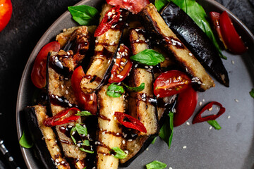 Appetizing salad of eggplants, tomatoes and basil in a black plate