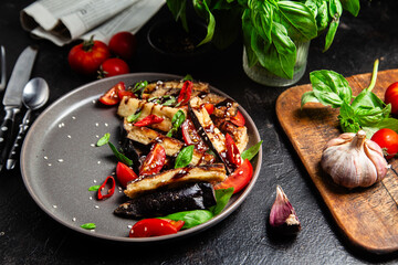 Appetizing salad of eggplants, tomatoes and basil in a black plate